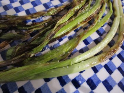 Wood-grill or griddle trimmed whole green garlic stems in their skins to eat like calçots, the Catalan spring onions served with romesco sauce.