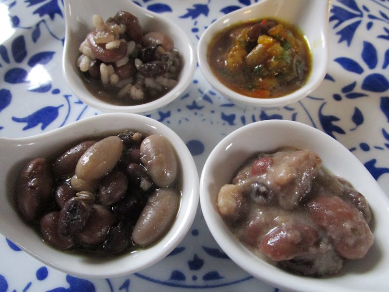 Tasting spoonfuls of flavoured beans: (clockwise from top left) with rice, with sofrito, with cheese and breadcrumbs, or just with garlic. Tasting spoonfuls of flavoured beans: (clockwise from top left) with rice, with sofrito, with cheese and breadcrumbs, or just with garlic.
